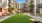 Large grass lawn in the courtyard with seating and a tv